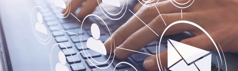 Hands typing on a computer keyboard with digital icons of emails and people, symbolizing email marketing and networking