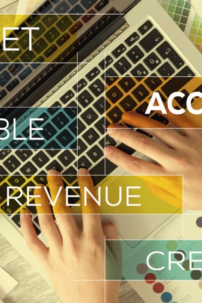 Accountant reviewing financial invoice with calculator, computer, and documents on wooden desk in modern office