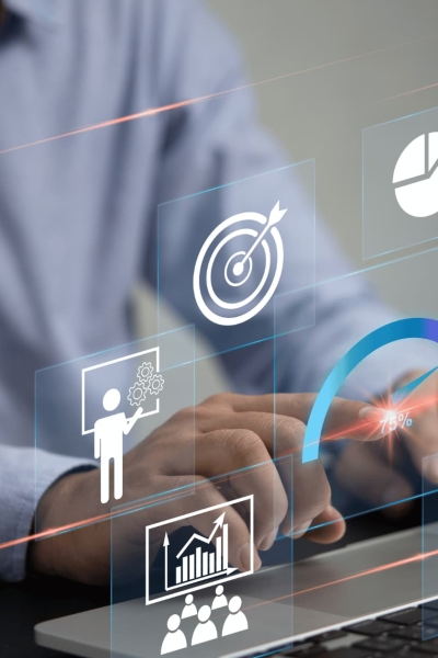 Person working on laptop with floating digital icons for business growth and productivity analytics